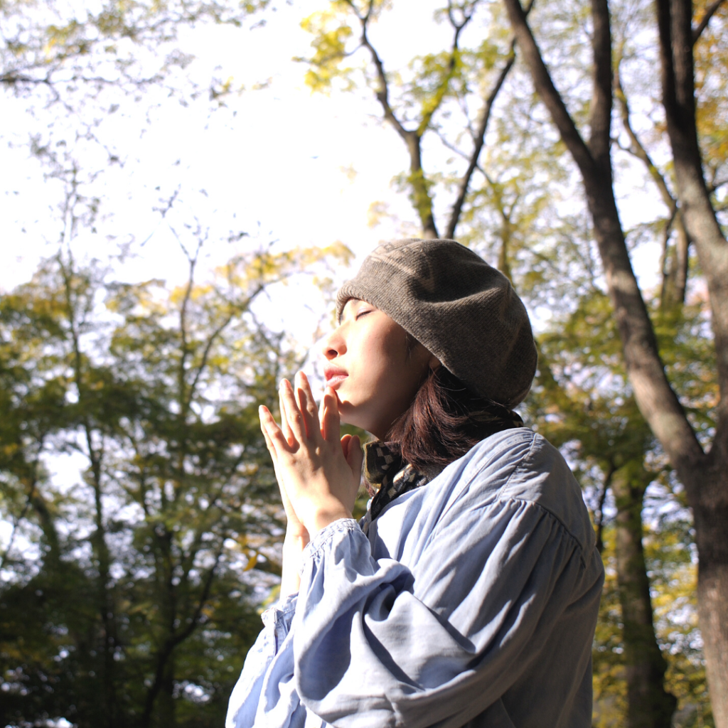 Asian woman praying, visualizing, and meditating in nature