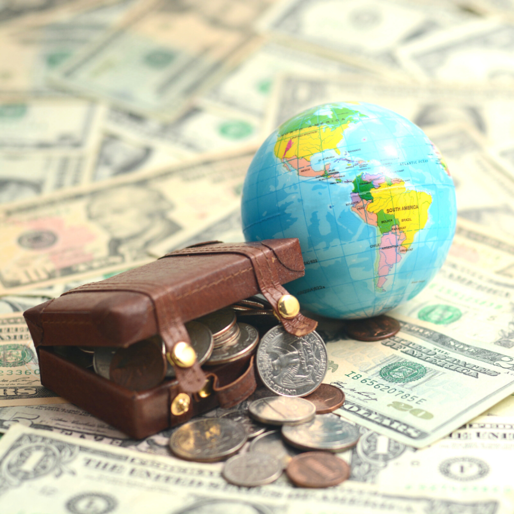 coins in a small luggage bag beside a globe with dollars background