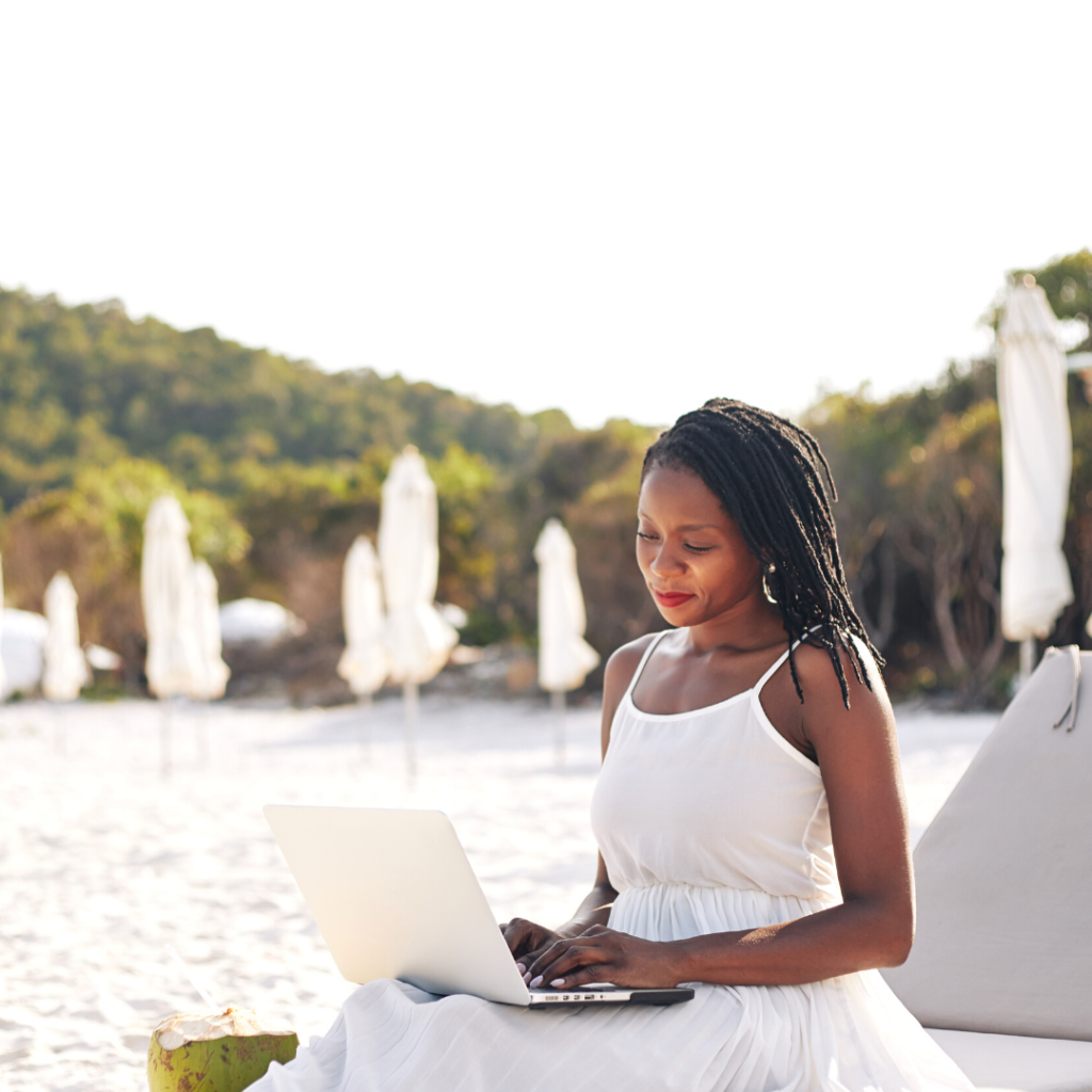 woman sitting in sun lounger with a laptop on her lap