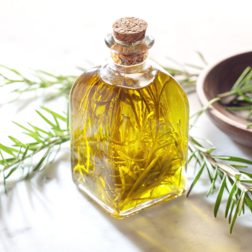 Rosemary Oil in a fancy bottle with fresh sprigs and plate