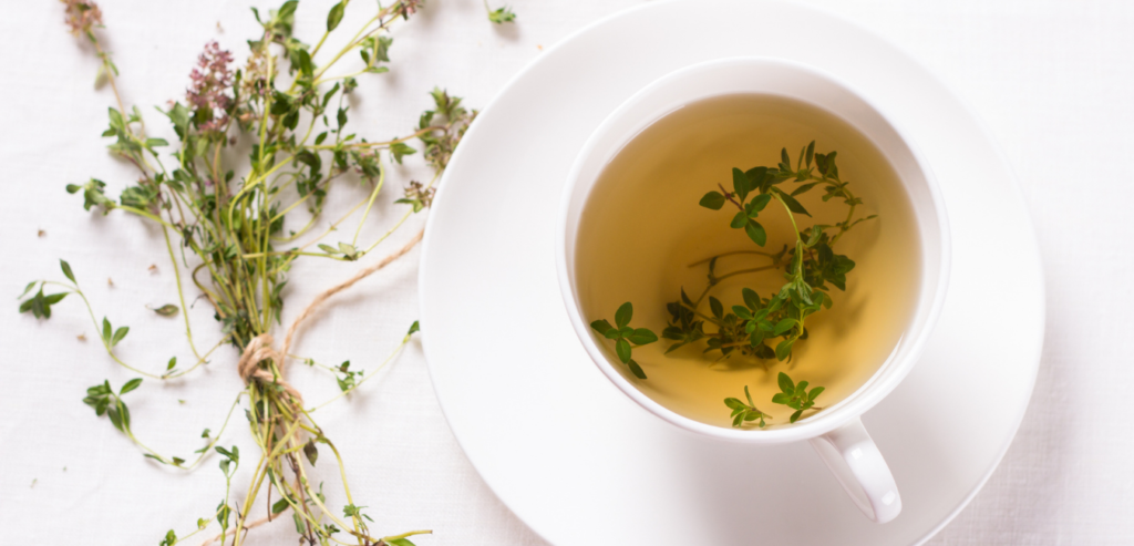 Thyme Tea with fresh thyme sprigs in a white hot tea cup