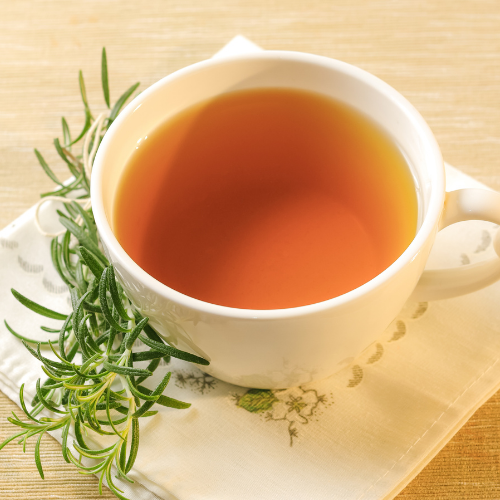 Rosemary Tea in a white cup with hot water and fresh rosemary sprigs